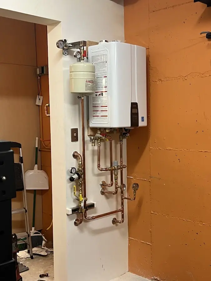 Plumbing technician inspecting water heater connections in Riverside